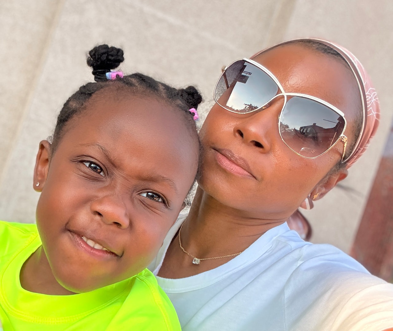 Maggie and her daughter cheek to cheek outdoors on an everyday afternoon